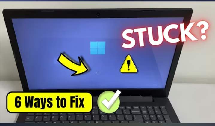 Windows 11 laptop stuck on a black loading screen with the spinning dots circle under the Windows logo